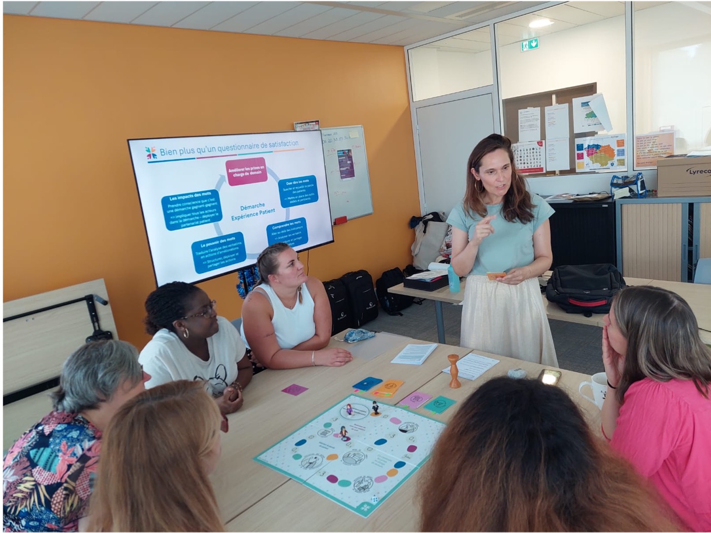 Marie-Catherine Truong anime une formation devant une équipe réunie autour du plateau de jeu